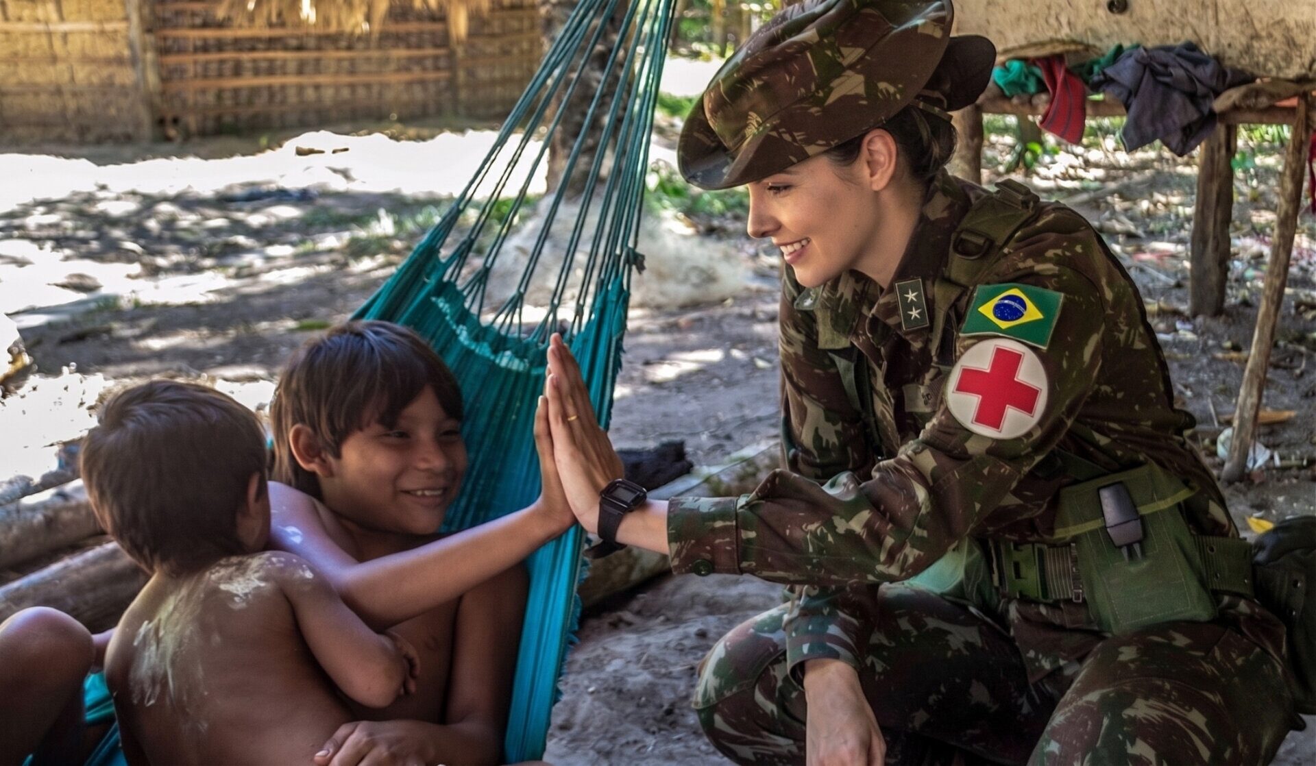 Oficial médica do Exército Brasileiro atendendo criança indígena em missão de saúde