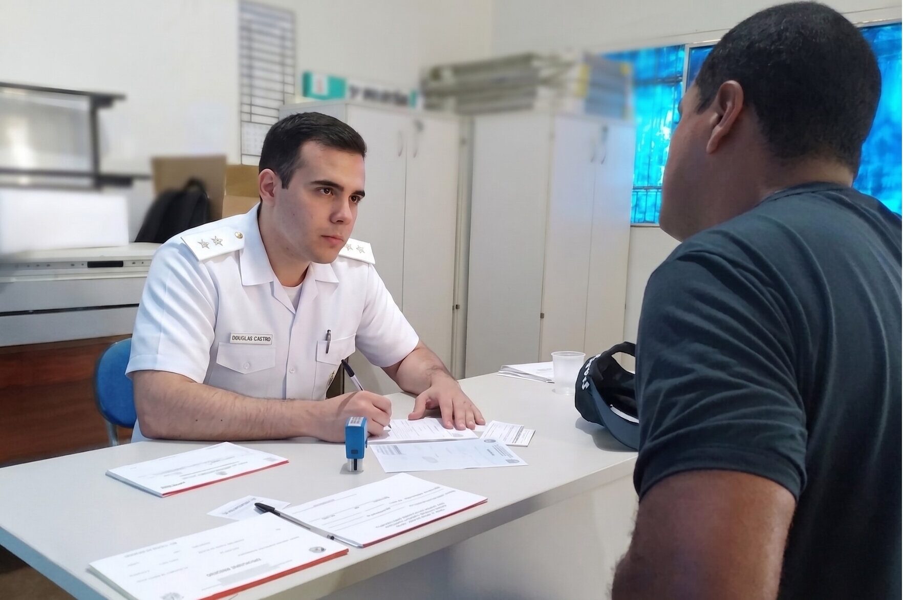 Oficial médica do Exército Brasileiro atendendo paciente em consultório militar